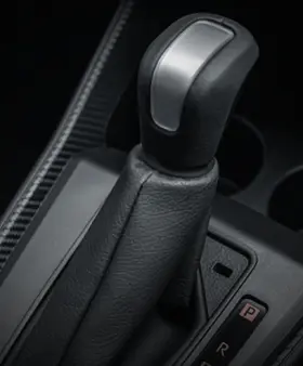 Perodua car near pale concrete steps, gentle structure framing the scene.